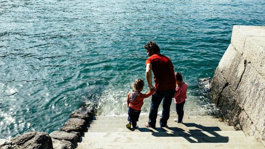 a man and two children walking up a flight of stairs